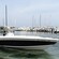 A man steers a boat through the marina in Cartagena Bay, with other boats lined up in the background